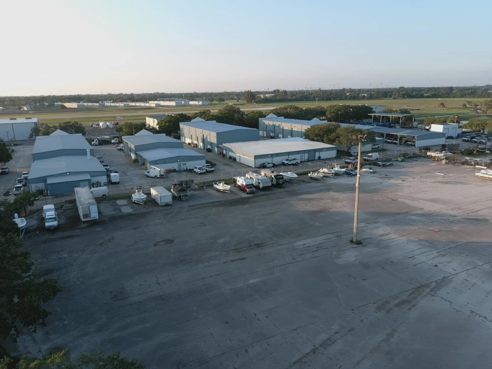 Drone aerial of storage unit parking lot with cars, trucks and RVs